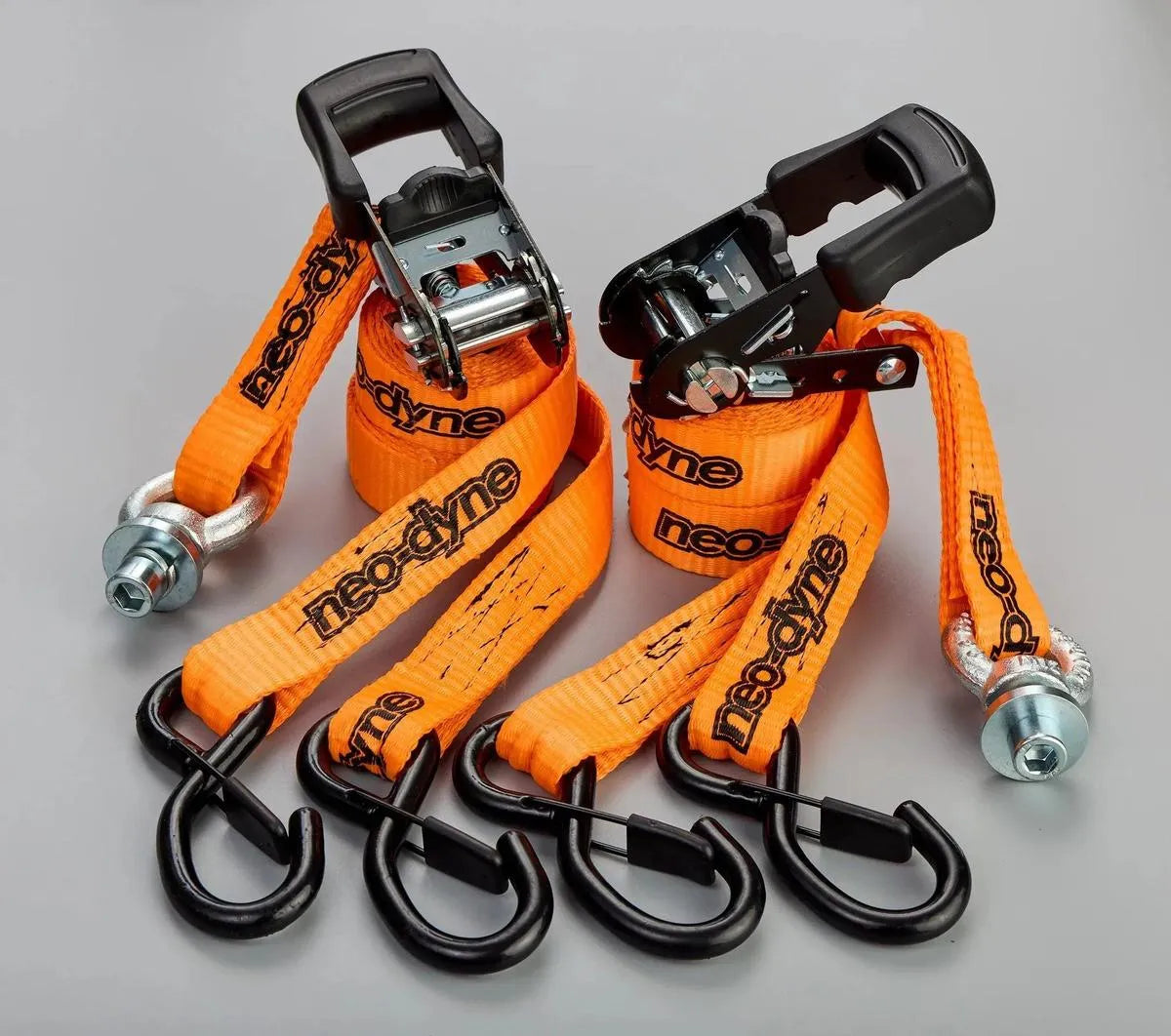 Two Neo-Dyne orange ratchet straps with black hooks on a gray background